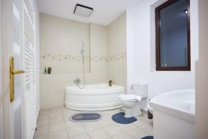 a bathroom with a tub and a toilet and a sink at Caragiale Apartment in Bucharest +30 photos