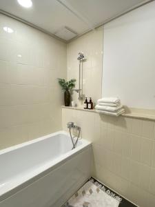uma casa de banho branca com uma banheira e um espelho. em Хайвилл парк однокомнатные апартаменты em Astana