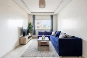 salon z niebieską kanapą i telewizorem w obiekcie Rabat Centro Apartments w mieście Rabat