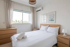 1 dormitorio con 1 cama blanca grande y ventana en Rabat Centro Apartments, en Rabat