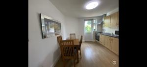 eine Küche mit einem Tisch und Stühlen im Zimmer in der Unterkunft Lovely one bedroom flat in Hendon in The Hyde