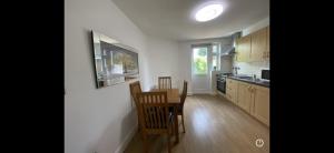 a kitchen with a table and chairs in a room at Lovely one bedroom flat in Hendon in The Hyde