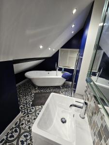 a bathroom with a white sink and a tub at Startop Farmhouse in Marsworth