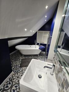 ein Badezimmer mit einem weißen Waschbecken und einer Badewanne in der Unterkunft Startop Farmhouse in Marsworth