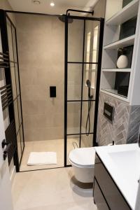 a bathroom with a shower with a toilet and a sink at Modern 2 bed 2 bath Fitzrovia apartment on Charlotte Street in London
