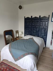 a bedroom with a bed with a blue and white blanket at maison centre ville, 15km de la mer in Challans