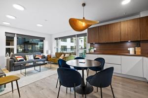 a kitchen and living room with a table and chairs at Venture Vacations - Unwind in Luxury Steps From Smáralind Mall in Reykjavík