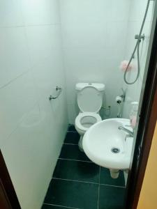 ein Badezimmer mit einem weißen WC und einem Waschbecken in der Unterkunft RAS Hotel in Kuala Lumpur