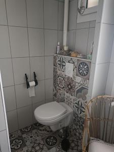 a bathroom with a toilet and a tiled floor at maison centre ville, 15km de la mer in Challans