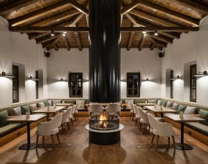 un restaurante con mesas y sillas y una hoguera en Unedo All Seasons Hotel en Palaios Panteleimon