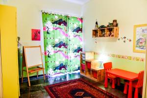 Zimmer mit einem Schreibtisch, einem Tisch, einem Tisch und einem Spiegel in der Unterkunft Colourful Apt in Nea Smyrni in Athen