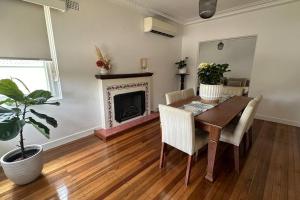 una sala da pranzo con tavolo e camino di Delightful Home with Amazing city views! a Sydney