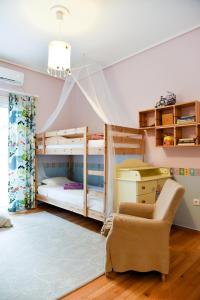 1 Schlafzimmer mit 2 Etagenbetten und einem Stuhl in der Unterkunft Colourful Apt in Nea Smyrni in Athen