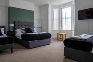 a bedroom with a bed and a chair in it at Central 6Bed Retreat - Your Perfect Coventry Holiday Home Away in Coventry