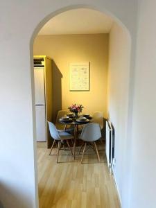 a dining room with a table and chairs and a kitchen at City Centre Riverside Apartment in Winchester