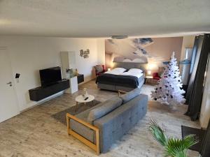 a living room with a christmas tree and a bed at Garden-Loft in Stadelhofen