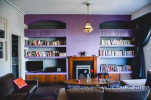 ein Wohnzimmer mit lila Wänden und einem Couchtisch in der Unterkunft Colourful Apt in Nea Smyrni in Athen