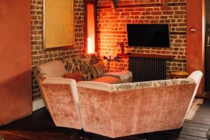 a living room with a couch and a fireplace at The George & Heart House in Kent