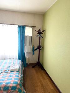een kamer met een slaapkamer met een bed en een ventilator bij PENSION YunShuiYao雲水瑶民宿 in Furano