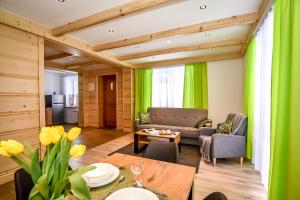 sala de estar con cortinas verdes y mesa en Domki u Jasia, en Zakopane