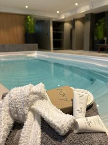 a towel and a cup next to a swimming pool at Hotell Esplanad in Växjö