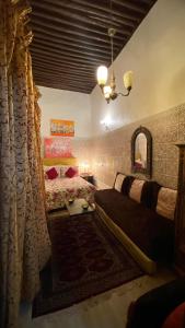 a bedroom with a bed and a couch and a mirror at DAR LALLA Aicha 2 in Rabat