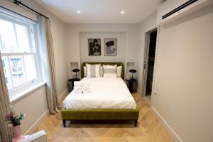 a bedroom with a bed with two towels on it at Modern 2 bed 2 bath Fitzrovia apartment on Charlotte Street in London