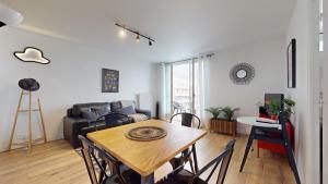 a living room with a table and a couch at Appartement PLEIN-CIEL in Villeurbanne