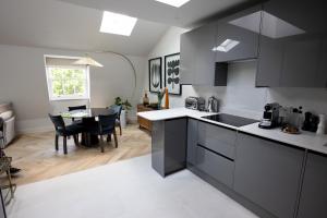 a kitchen with black and white cabinets and a table at Modern 2 bed 2 bath Fitzrovia apartment on Charlotte Street in London