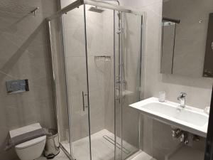 a bathroom with a shower and a sink and a toilet at Oikos 9 Rooms and Suites in Nafpaktos