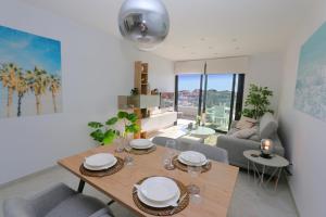 a dining room and living room with a table and chairs at Flamenca Village south facing close to the beach (VDE-045) in Orihuela