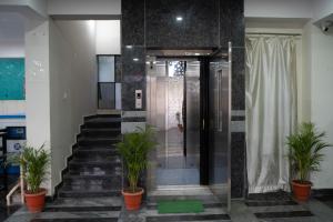 a lobby with stairs and potted plants in a building at Yellow Bells Gachibowli in Hyderabad