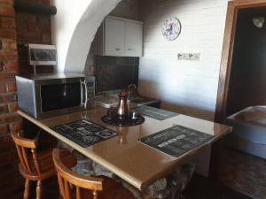 a kitchen with a table with a microwave and a counter top at Serendipity self catering one bedroom apartment in Despatch