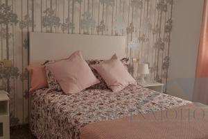 Un dormitorio con una cama con almohadas encima. en Ático del sol, en Fuengirola