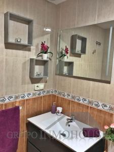 un baño con lavabo y espejo en Ático del sol, en Fuengirola