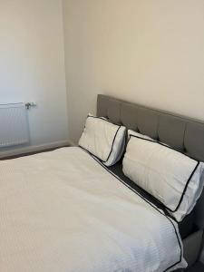 a bed with two pillows on it in a room at Stylish Luxury new 2 bedroom Apartment in Dartford