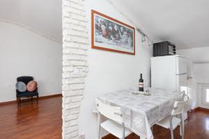 uma sala de jantar com uma mesa e um frigorífico em Loft Rossetti em Trieste