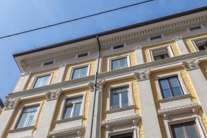 um edifício amarelo com janelas em cima em Loft Rossetti em Trieste