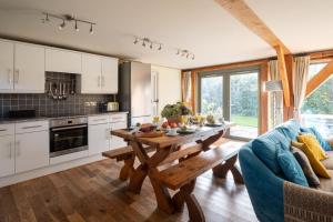 uma cozinha e sala de estar com uma mesa de madeira em The Nook em Holbeton