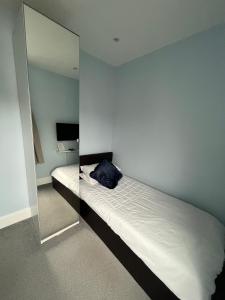 1 dormitorio con espejo junto a la cama en Modern En-Suite Rooms Town Centre Self-Check In en Barnsley