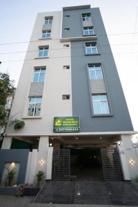 un edificio blanco con un cartel delante en Yellow Bells Gachibowli en Hyderabad