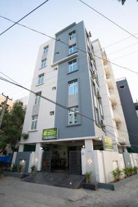 un edificio blanco alto con un restaurante frente a él en Yellow Bells Gachibowli, en Hyderabad