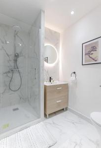 a white bathroom with a shower and a sink at Magnifique Studio Clichy in Clichy