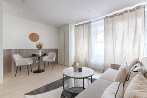 a living room with a couch and a table at Magnifique Studio Clichy in Clichy