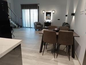 a dining room and living room with a table and chairs at Oikos 9 Rooms and Suites in Nafpaktos