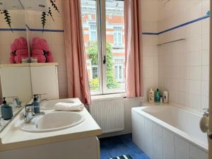 baño con lavabo, bañera y ventana en L&L apartment, en Bruselas