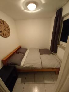 1 dormitorio con 1 cama y reloj en la pared en Ap5 Nature Ardennes Economy class apartment, en La Calamine