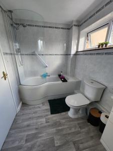 a white bathroom with a tub and a toilet at Room in Crawley/Gatwick/West Sussex in Ifield
