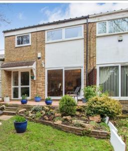 a brick house with a garden in front of it at Room in Crawley/Gatwick/West Sussex in Ifield