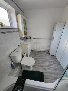 a bathroom with a toilet and a tub and a sink at Room in Crawley/Gatwick/West Sussex in Ifield